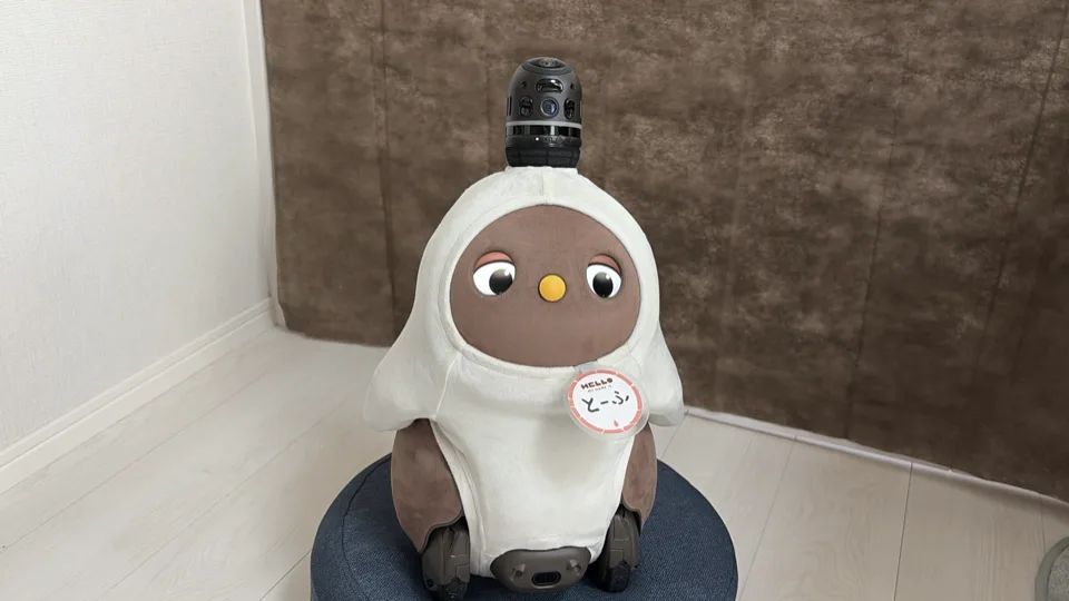 白い服を着てクッションに座るLOVOT