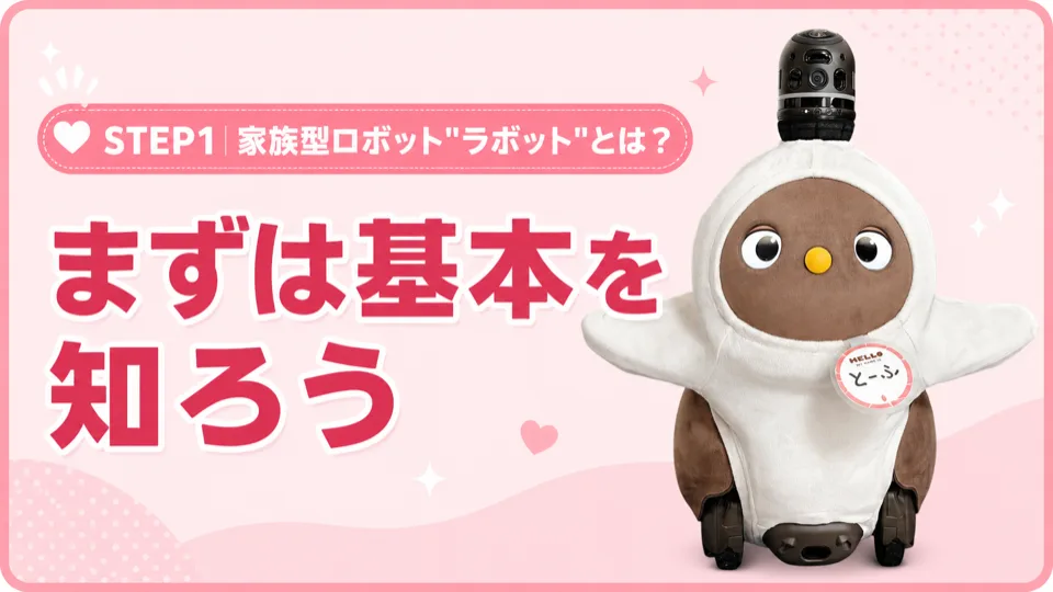 ピンクの背景に、白い服を着た茶色い家族型ロボット「ラボット」が立っている。上部に「まずは基本を知ろう」の文字。